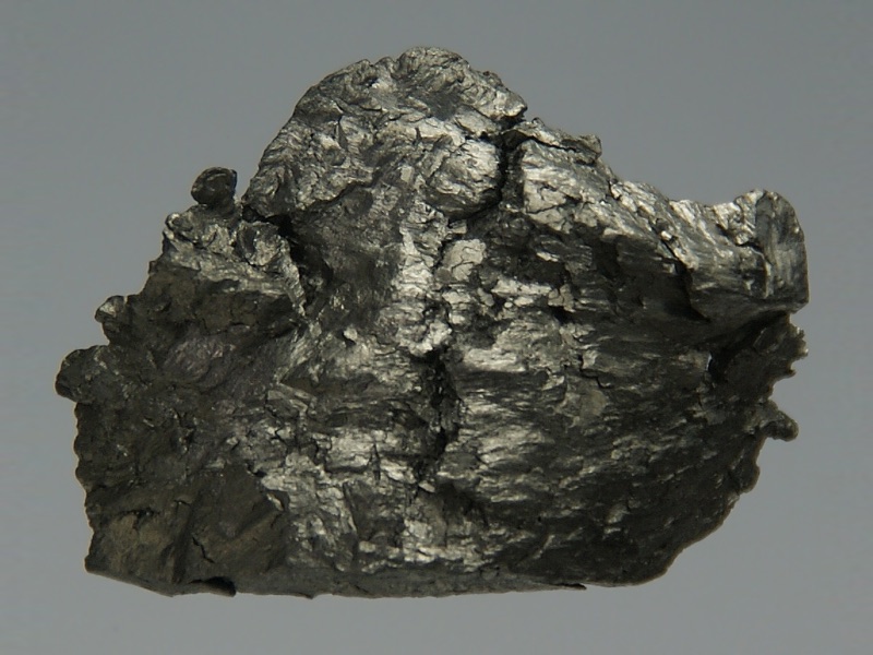 Gadolinium — Pure (99.95%) Amorphous Gadolinium, about 12 grams, 2 × 1.5 × 0.5 cm, cast in acrylic glass